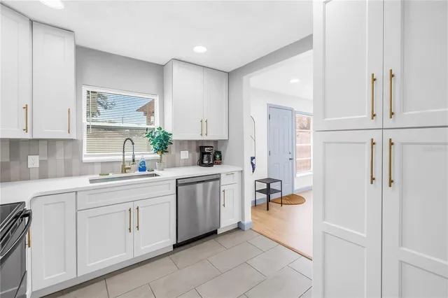 a kitchen with white cabinets and white appliances