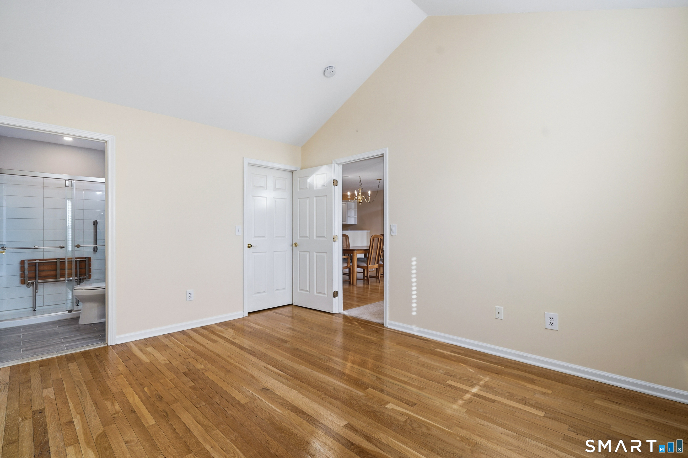 31 St George Place, Unit 31 Newtown, CT 06482 - Photo 19 of 30 a view of an empty room with wooden floor and a kitchen