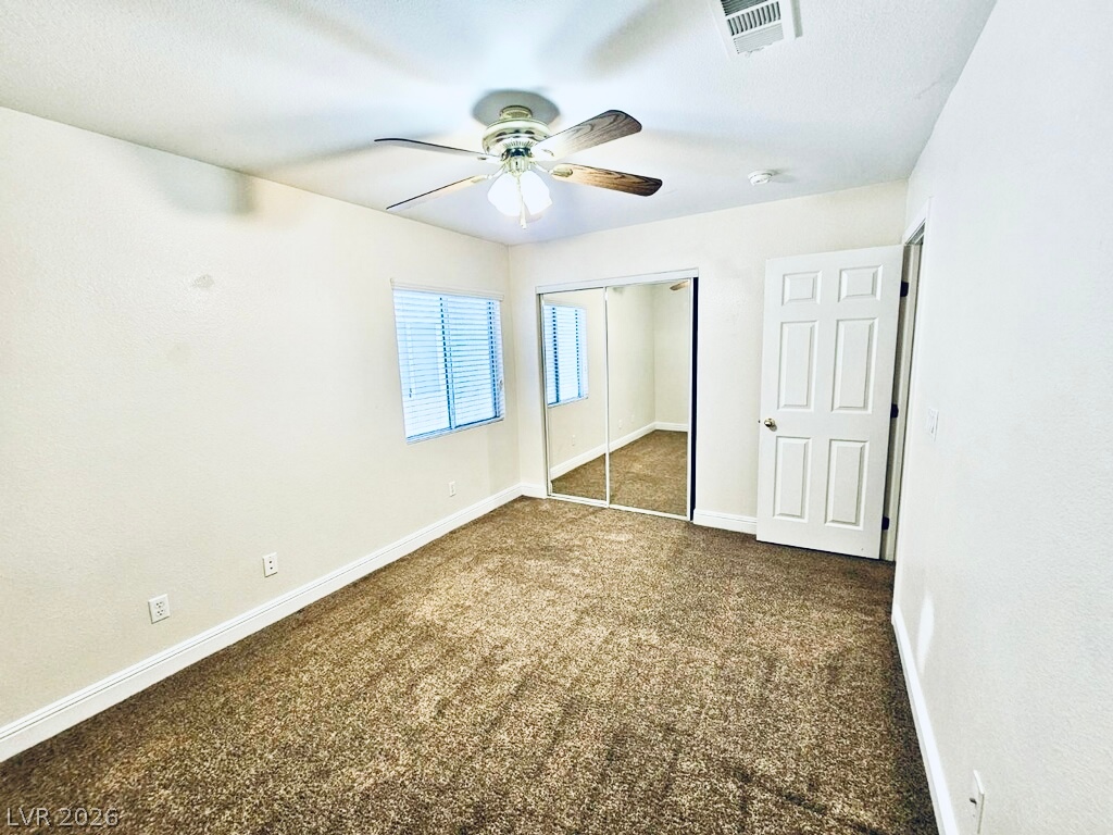 5953 Crumbling Ridge Street Henderson, NV 89011 - Photo 26 of 42 A well-lit bedroom provides comfort and style, featuring mirrored closet doors and a ceiling fan.