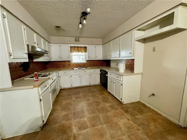 a kitchen with a sink a counter top space cabinets and appliances