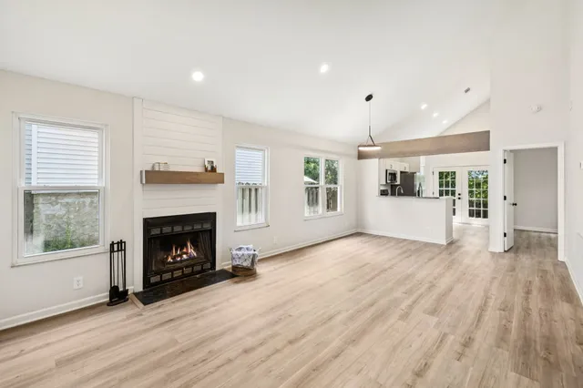 a view of a livingroom with wooden floor and a fireplace