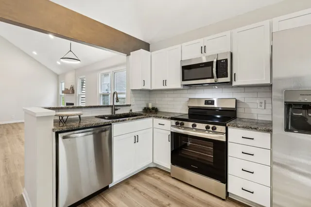 a kitchen with stainless steel appliances granite countertop a stove and a sink