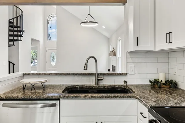 a kitchen with stainless steel appliances granite countertop a sink and a stove