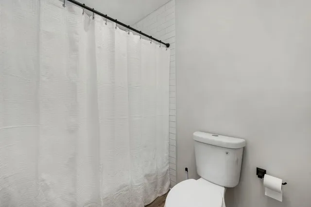 a white toilet sitting next to a white wall