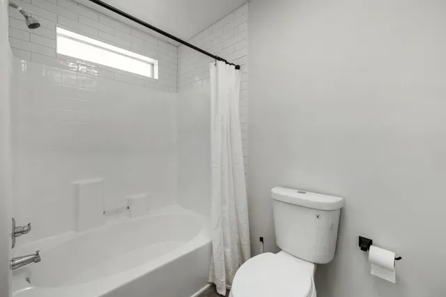 a white toilet sitting next to a bath tub