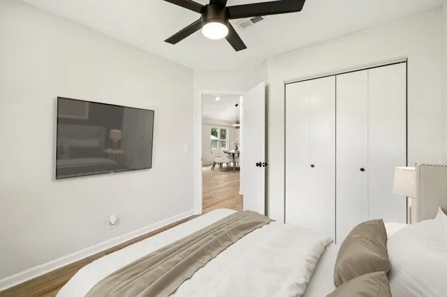 a bedroom with a bed and a chandelier fan