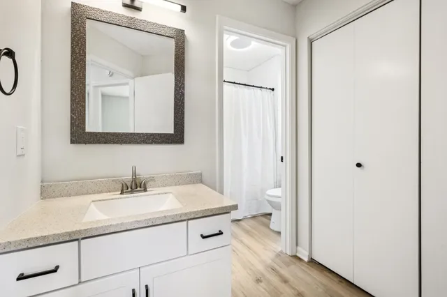 a en suite bathroom with a granite countertop sink and a mirror