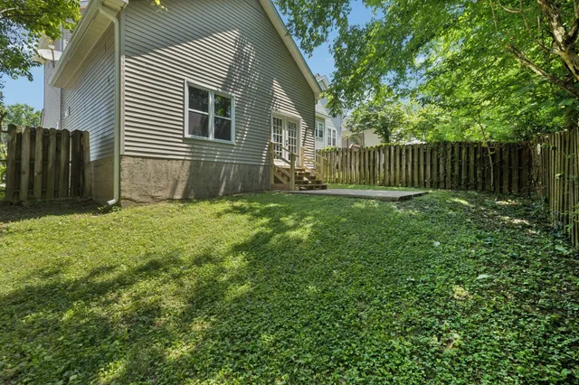 a view of a backyard with plants and wooden fence
