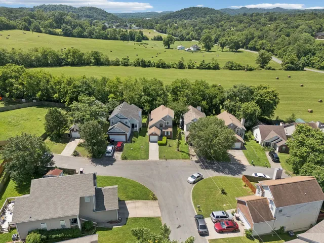 an aerial view of a house with a garden and lake view