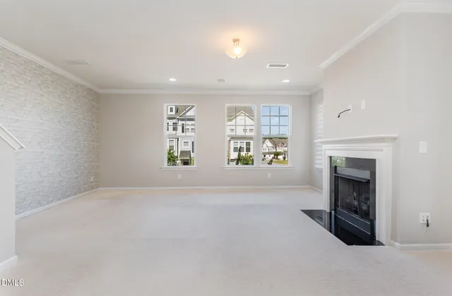 an empty room with windows and fireplace