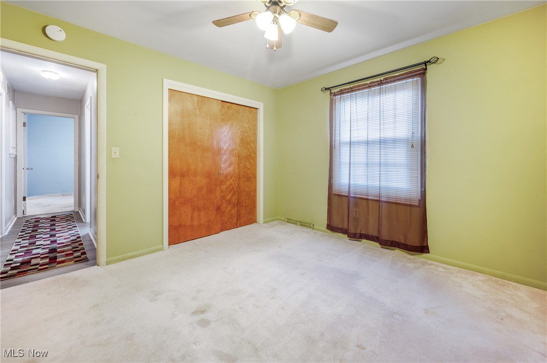 844 Roseland Road Alliance, OH 44601 - Photo 27 of 40 Unfurnished bedroom featuring a closet, ceiling fan, and light colored carpet