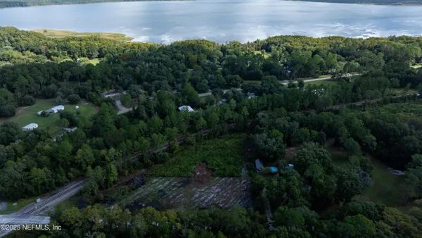 an aerial view of a house with a yard and lake view