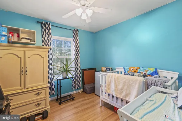 a living room with a baby crib furniture and a window