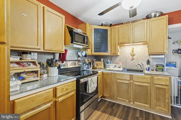 a kitchen with granite countertop a sink stainless steel appliances and cabinets