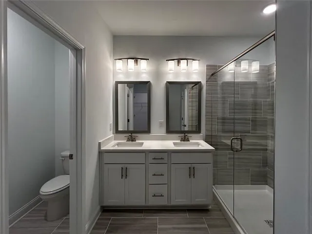 a bathroom with double sink and mirror with shower