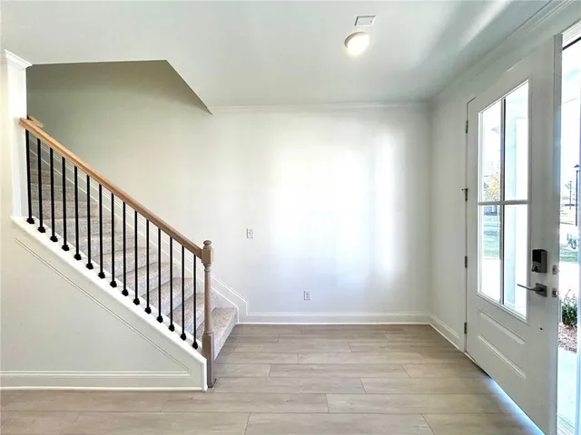 a view of a hallway with wooden floor and staircase