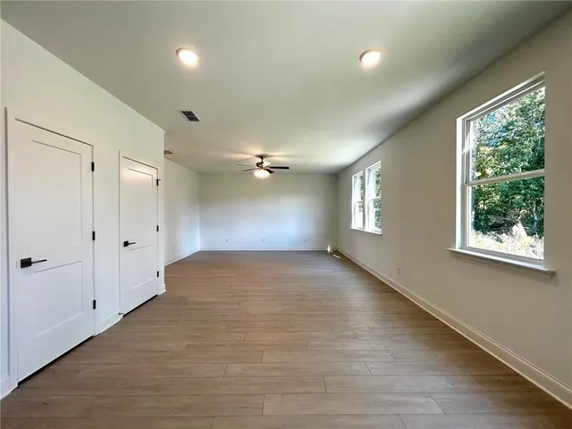 a view of empty room with a window and wooden floor