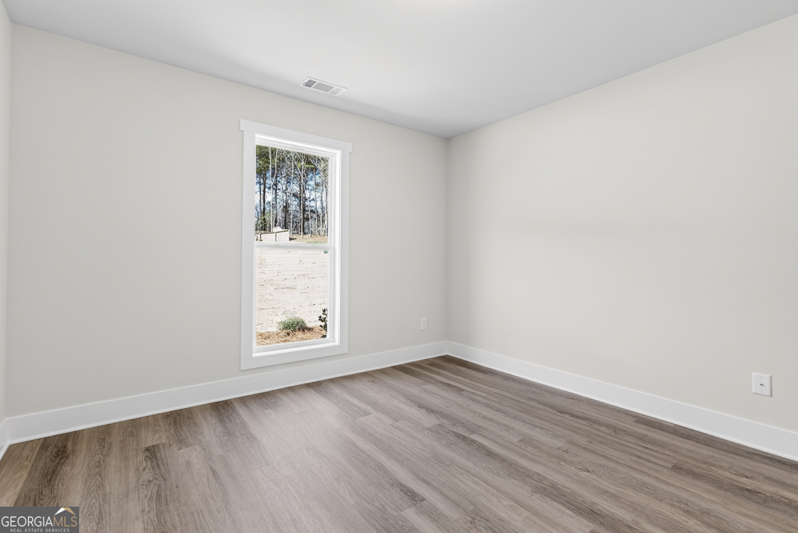 302 Mockingbird Lane, Unit 25 Winder, GA 30680 - Photo 22 of 38 an empty room with wooden floor and window