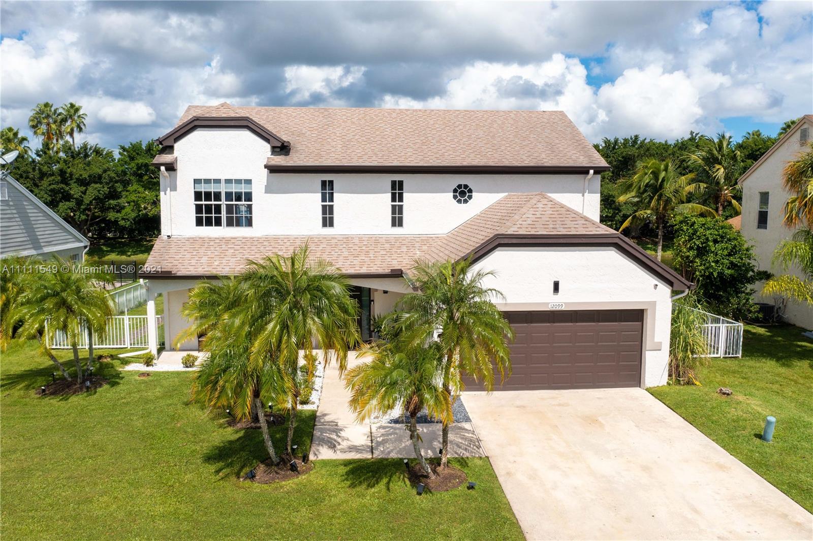 12099 Rockwell Way Boca Raton, FL 33428 - Photo 2 of 60 a front view of a house with a yard