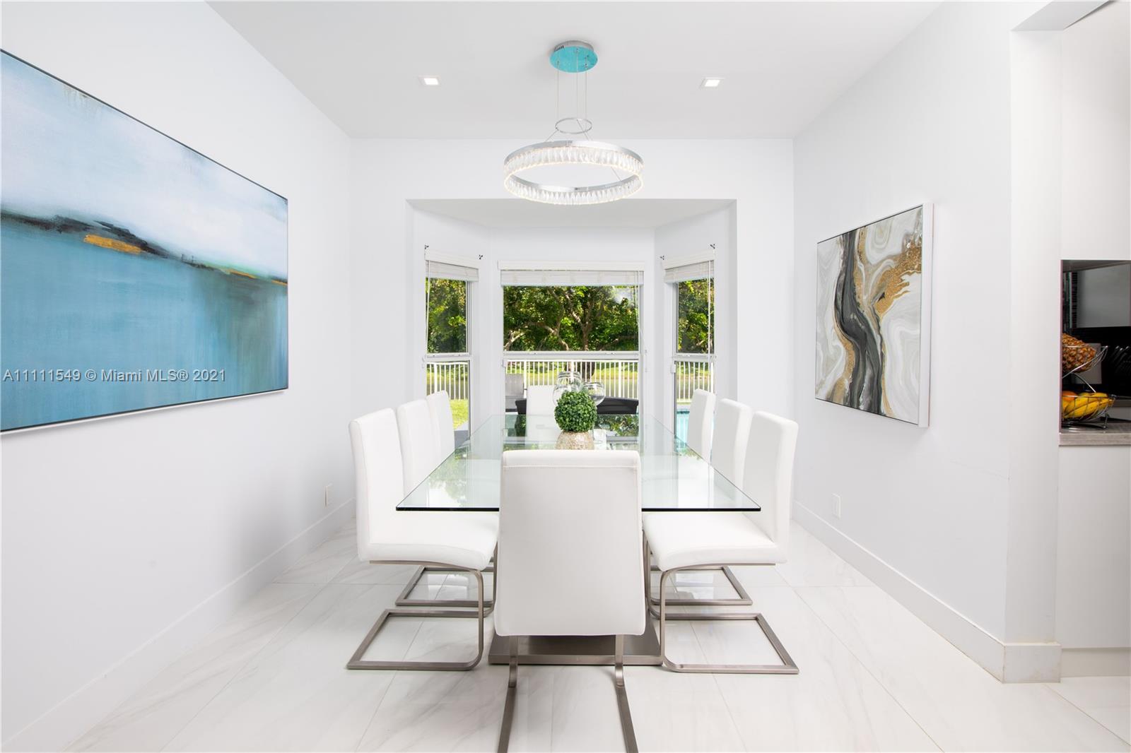12099 Rockwell Way Boca Raton, FL 33428 - Photo 17 of 60 a view of a dining room with furniture wooden floor and a chandelier
