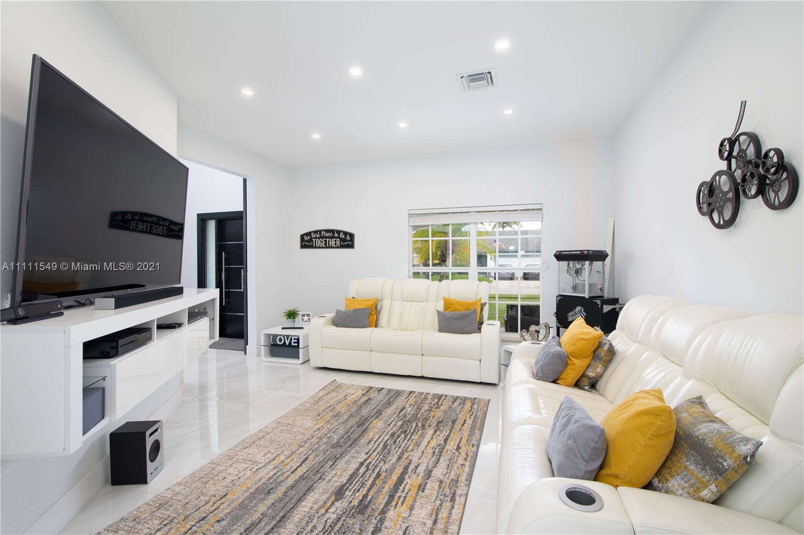 12099 Rockwell Way Boca Raton, FL 33428 - Photo 18 of 60 a living room with furniture flat screen tv and kitchen view