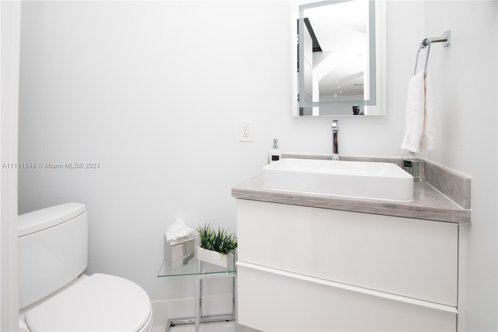 12099 Rockwell Way Boca Raton, FL 33428 - Photo 21 of 60 a bathroom with a sink a toilet and mirror
