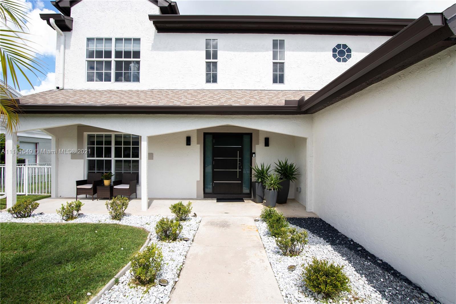 12099 Rockwell Way Boca Raton, FL 33428 - Photo 42 of 60 a front view of a house with garden and porch