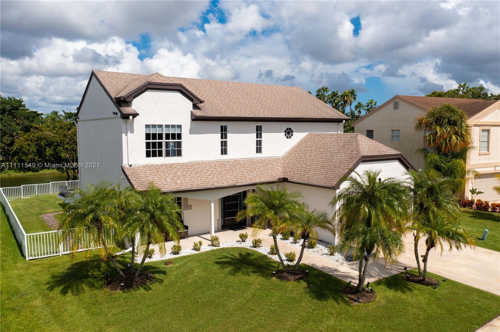 12099 Rockwell Way Boca Raton, FL 33428 - Photo 45 of 60 a view of a white house with a big yard and potted plants
