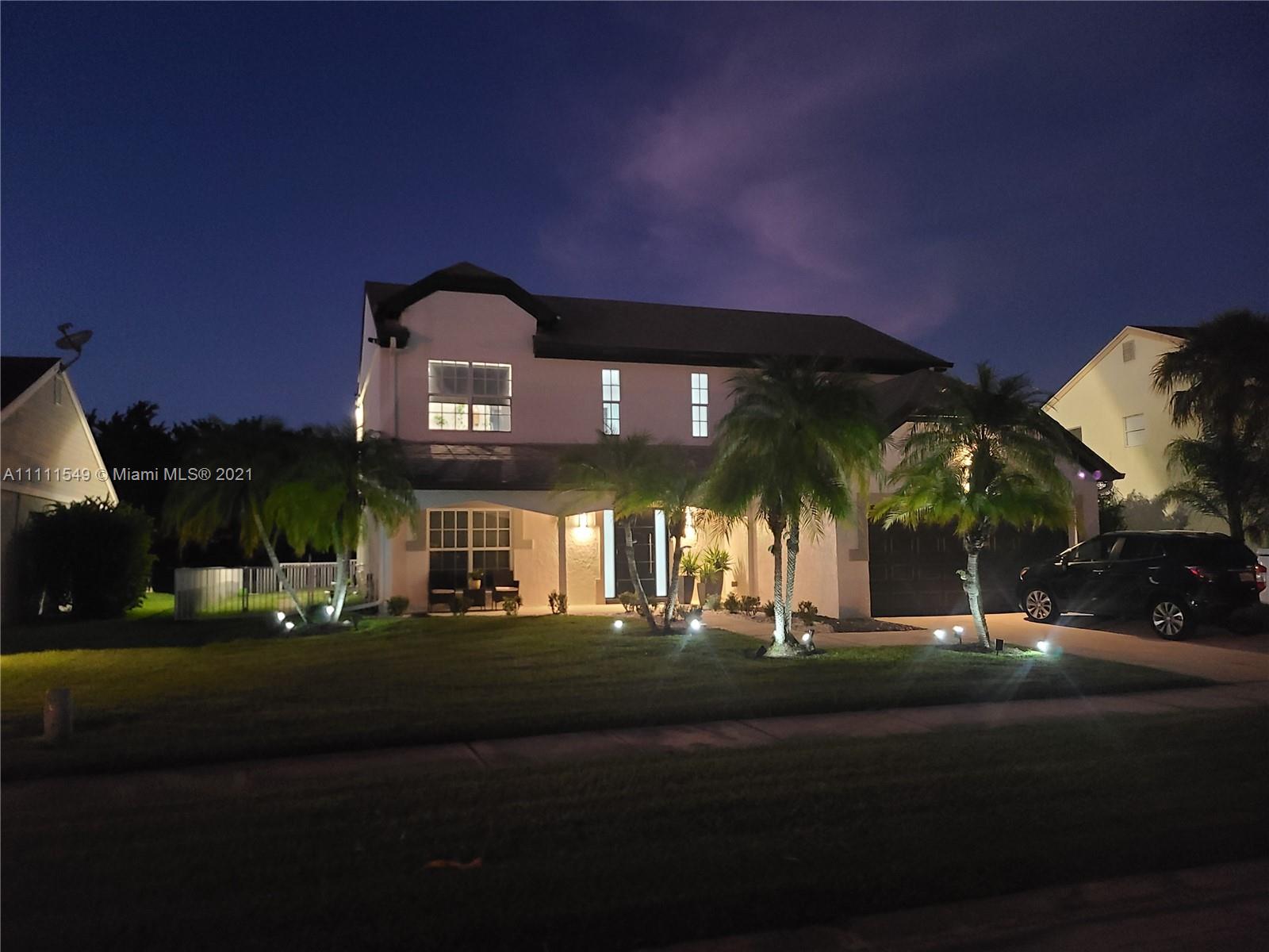 12099 Rockwell Way Boca Raton, FL 33428 - Photo 58 of 60 a front view of a house with a yard