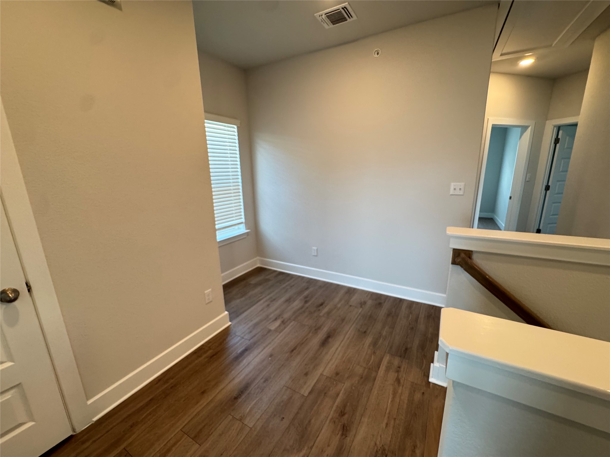 3000 Chisholm Trail Road, Unit 91 Round Rock, TX 78681 - Photo 14 of 27 Rich wood flooring complements the neutral walls, creating an inviting and adaptable upper-level space.