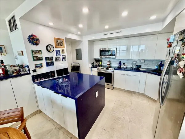 a large kitchen with stainless steel appliances granite countertop a sink and cabinets
