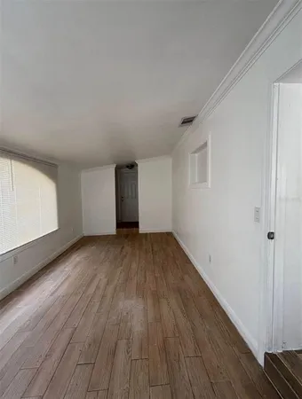 a view of a room with wooden floor and window