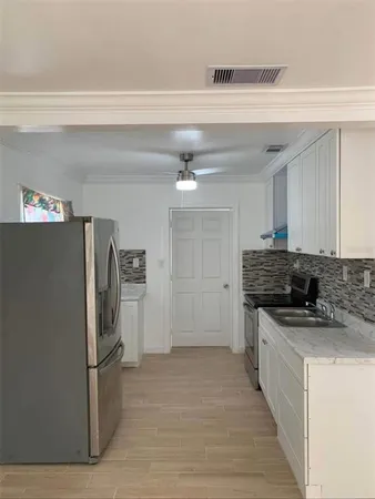 a kitchen with stainless steel appliances granite countertop a refrigerator and a stove