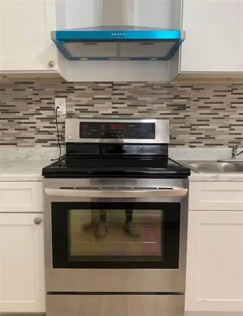 a stove top oven sitting inside of a kitchen