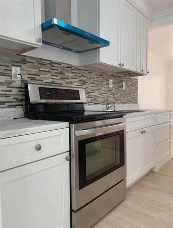 a stove top oven sitting inside of a kitchen