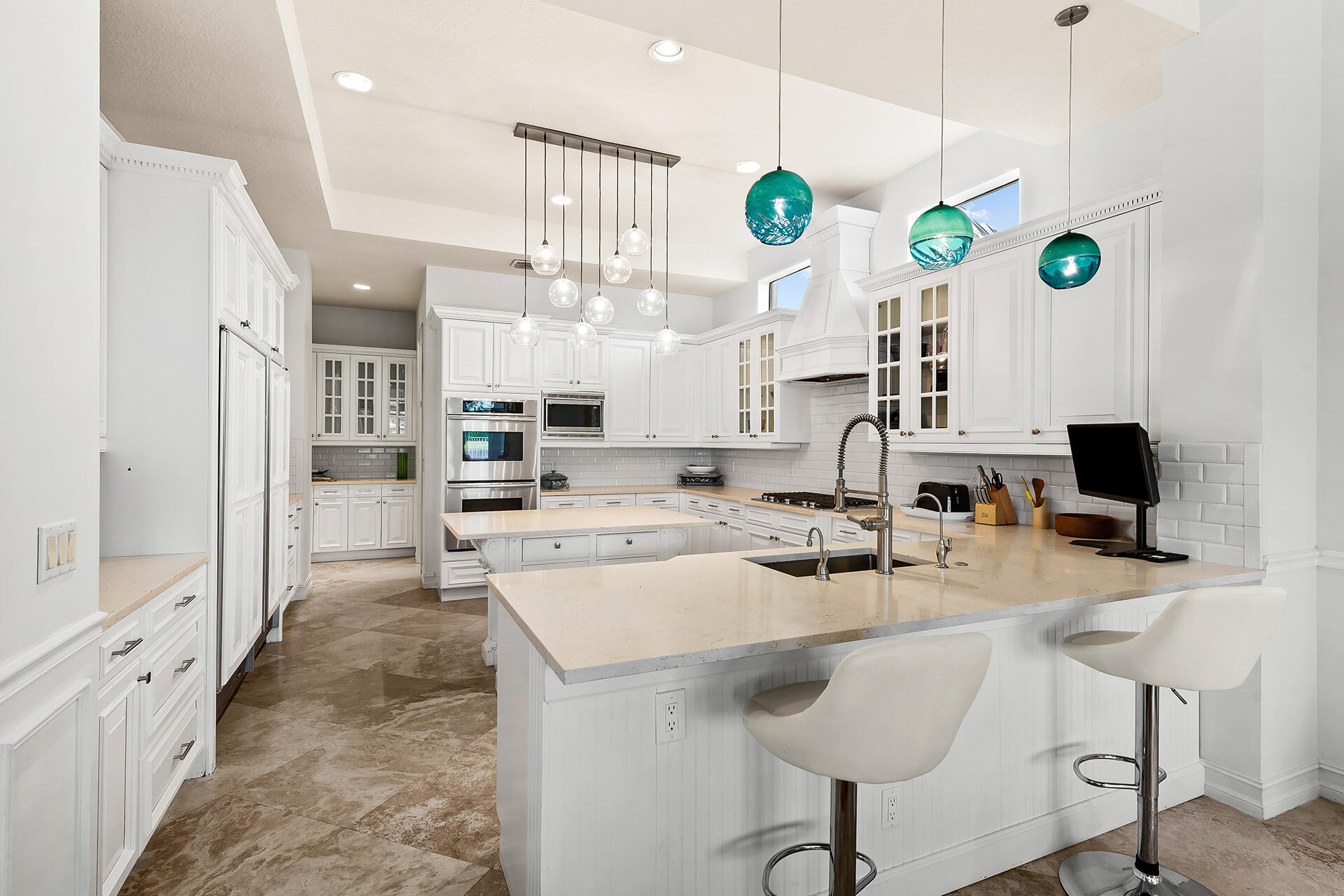 9455 Bridgebrook Drive Boca Raton, FL 33496 - Photo 14 of 63 a kitchen with stainless steel appliances a stove a sink a microwave a refrigerator a dining table chairs and couches with wooden floor