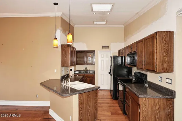a kitchen with stainless steel appliances granite countertop a sink a stove and a refrigerator