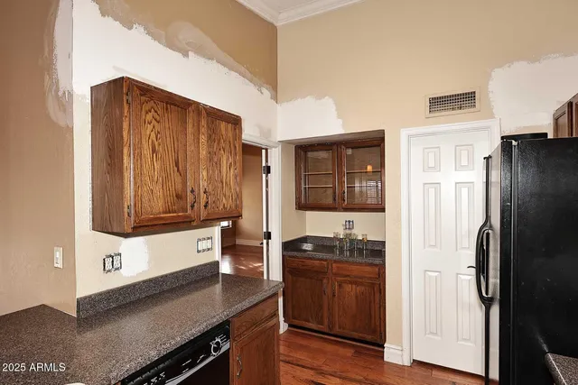 an empty room with wooden floor fireplace and windows