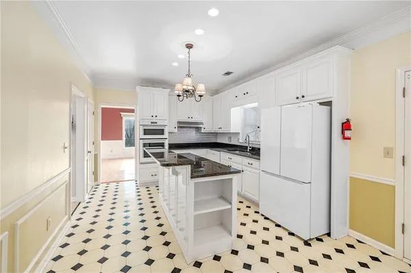 a kitchen with granite countertop a refrigerator and a sink