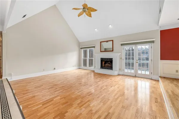 a view of empty room with wooden floor and fireplace
