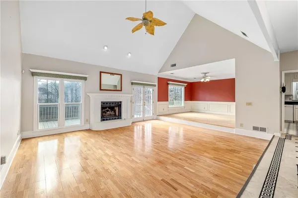 a view of empty room with wooden floor and fan
