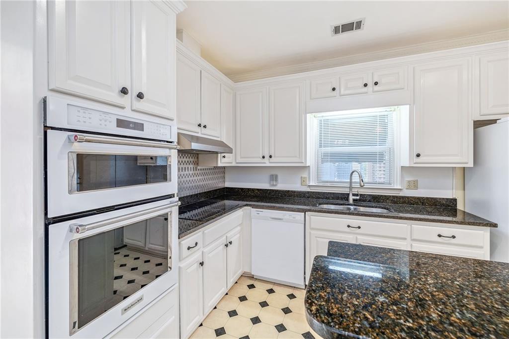 3374 Floral Court Suwanee, GA 30024 - Photo 10 of 54 a kitchen with granite countertop white cabinets white stainless steel appliances with a sink and dishwasher