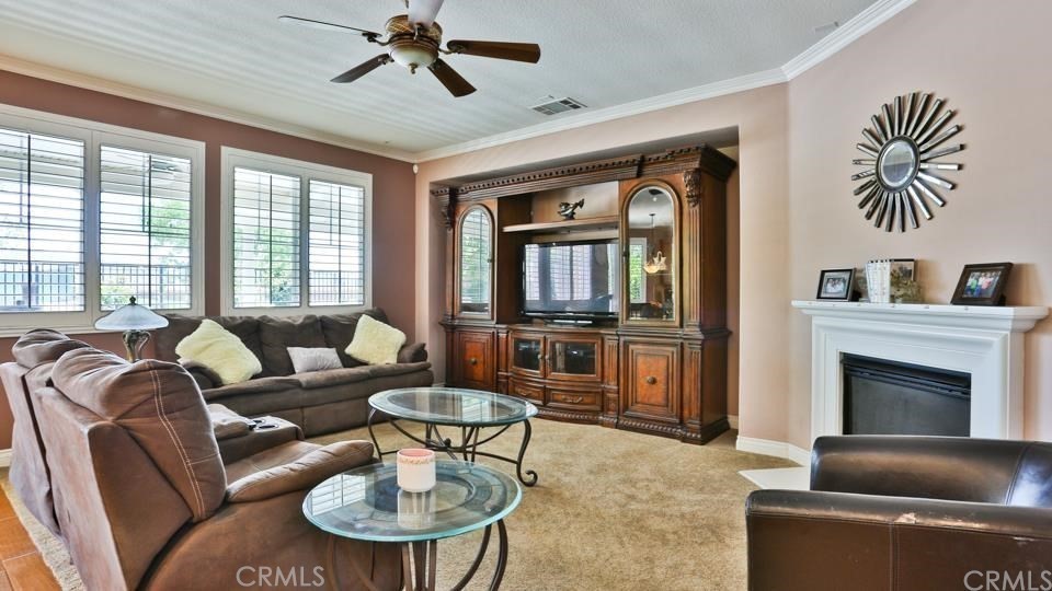 30240 Lamplighter Lane Menifee, CA 92584 - Photo 6 of 20 a living room with furniture a fireplace and a large window