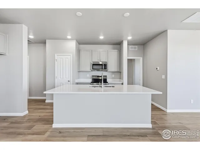 a view of kitchen with stainless steel appliances granite countertop a sink a stove and a refrigerator