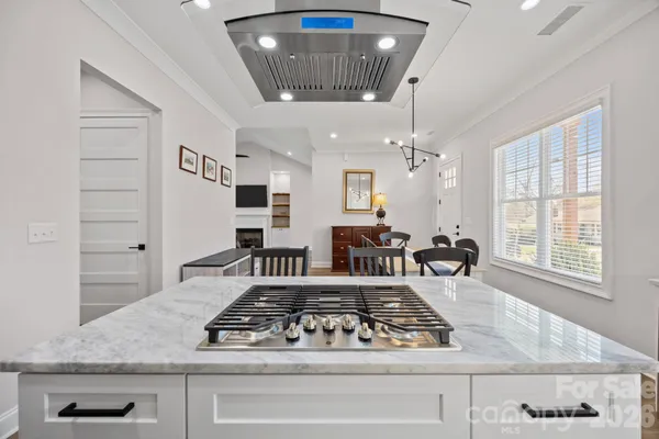 a kitchen with a stove a sink a refrigerator and chandelier