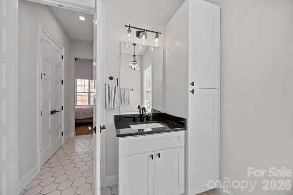 a bathroom with a granite countertop sink a mirror a vanity and a shower