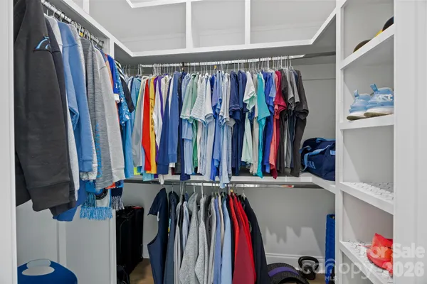 a view of walk in closet with clothes