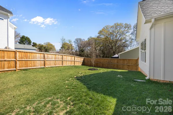 a view of a backyard with grass & palm trees