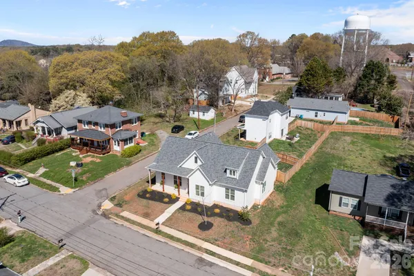 an aerial view of residential houses with outdoor space and parking