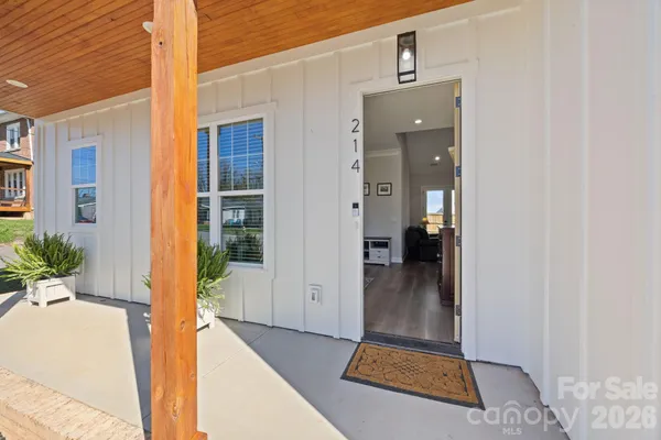 a view of a hallway with wooden floor and a living room